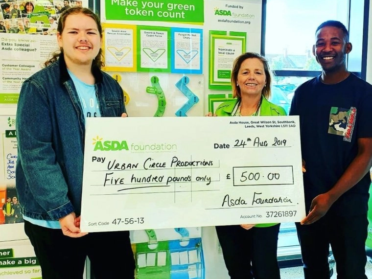 A picture of Dan with Nizmo holding a massive check